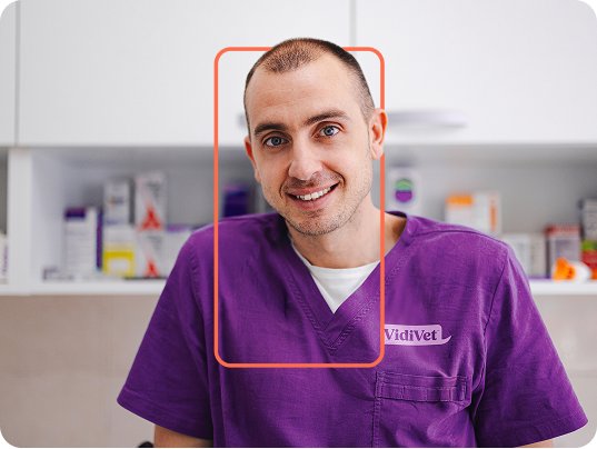 A smiling VidiVet vet in branded scrubs