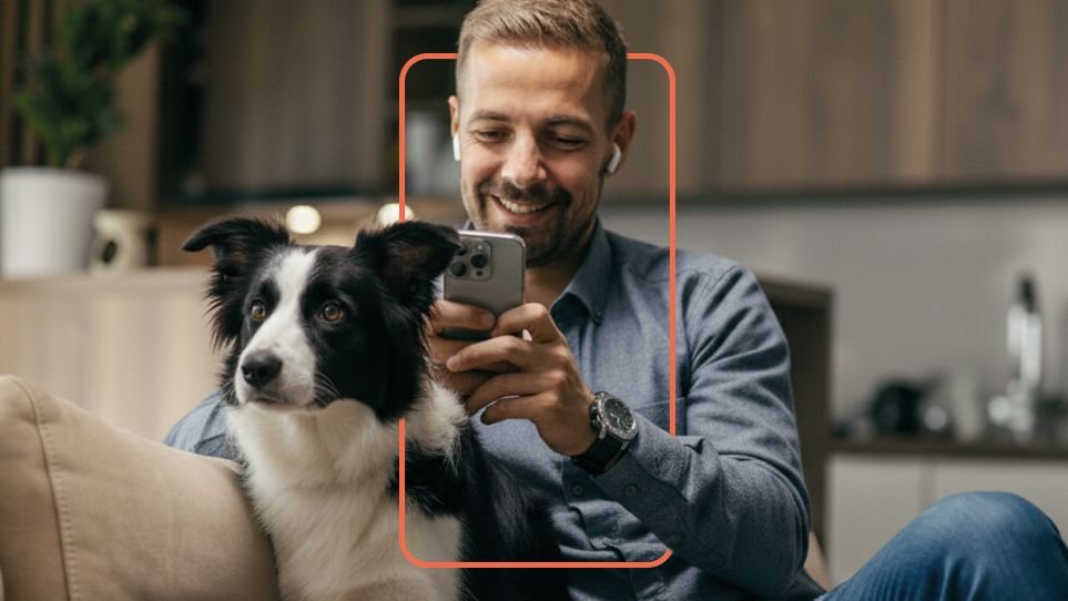 A man and his dog on the sofa, using the VidiVet app on his phone